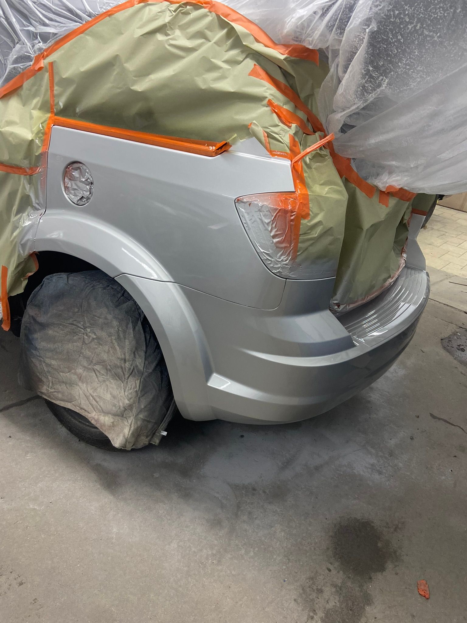 A Silver Car Is Covered in Plastic and Is Being Painted — Chicago, IL — Ecuamex Autobody Inc.