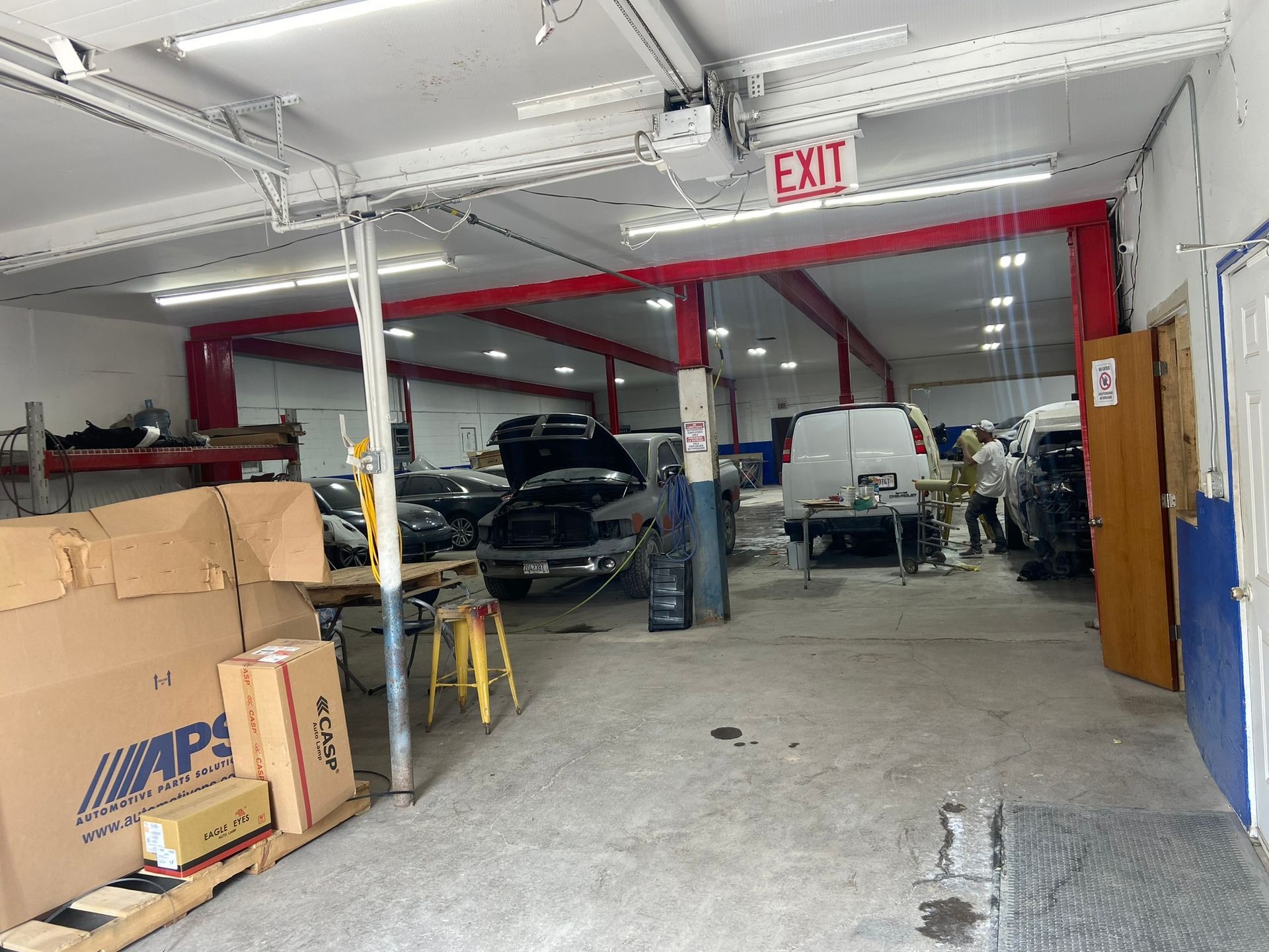 The Inside of A Car Repair Shop with A Red Exit Sign Hanging from The Ceiling — Chicago, IL — Ecuamex Autobody Inc.
