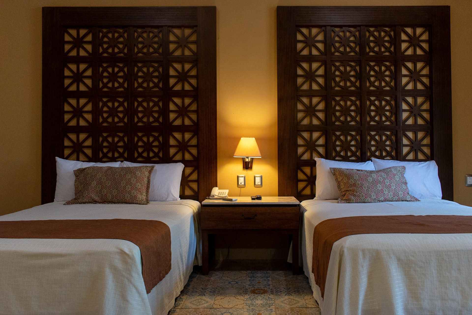 Una habitación de hotel con dos camas y dos lámparas.