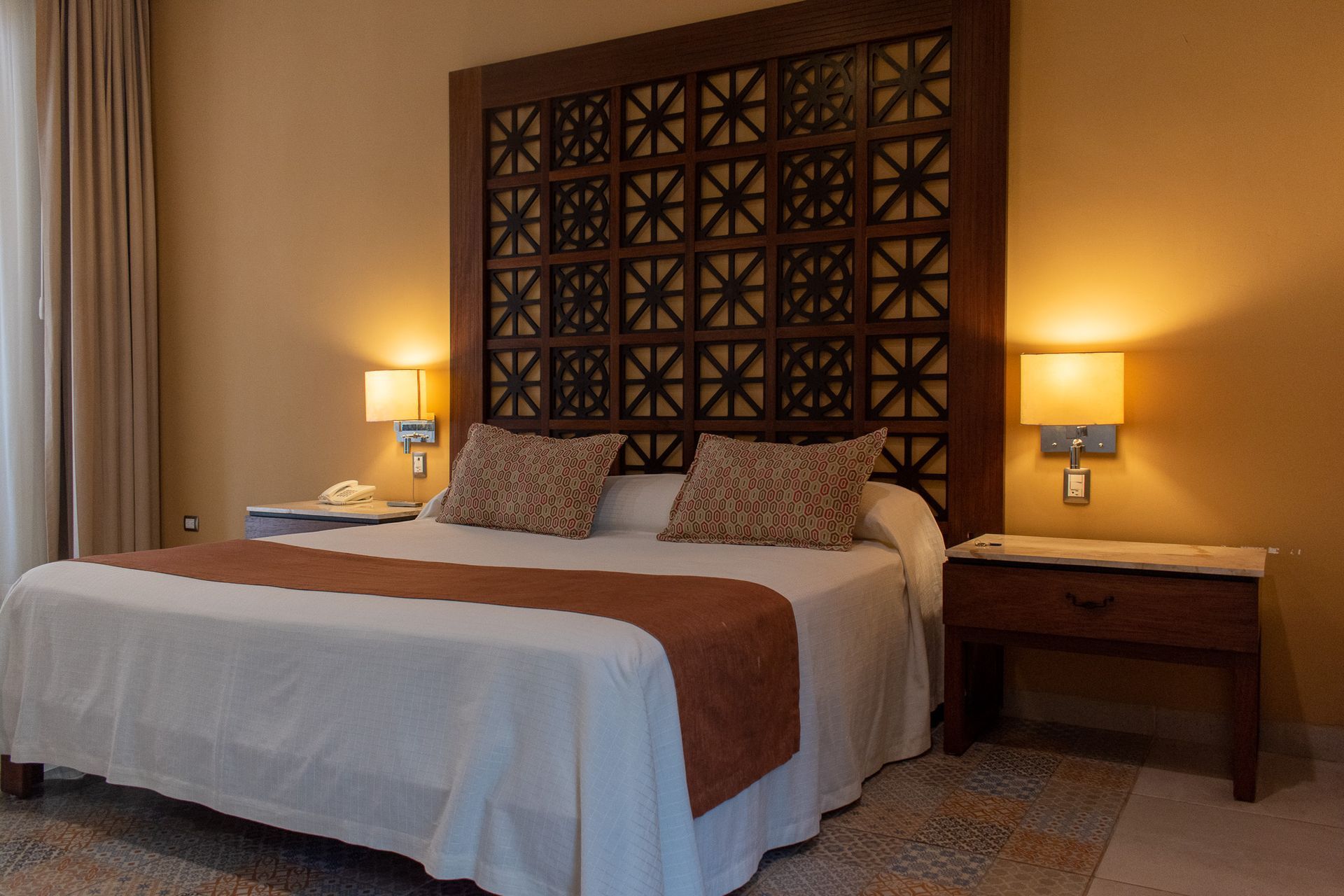Una habitación de hotel con una cama tamaño king y un cabecero de madera.