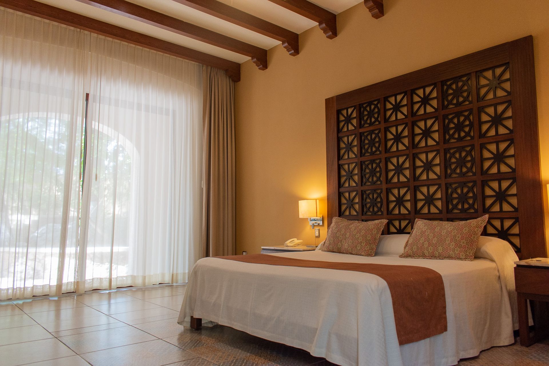 Una habitación de hotel con una cama tamaño king y una ventana grande.