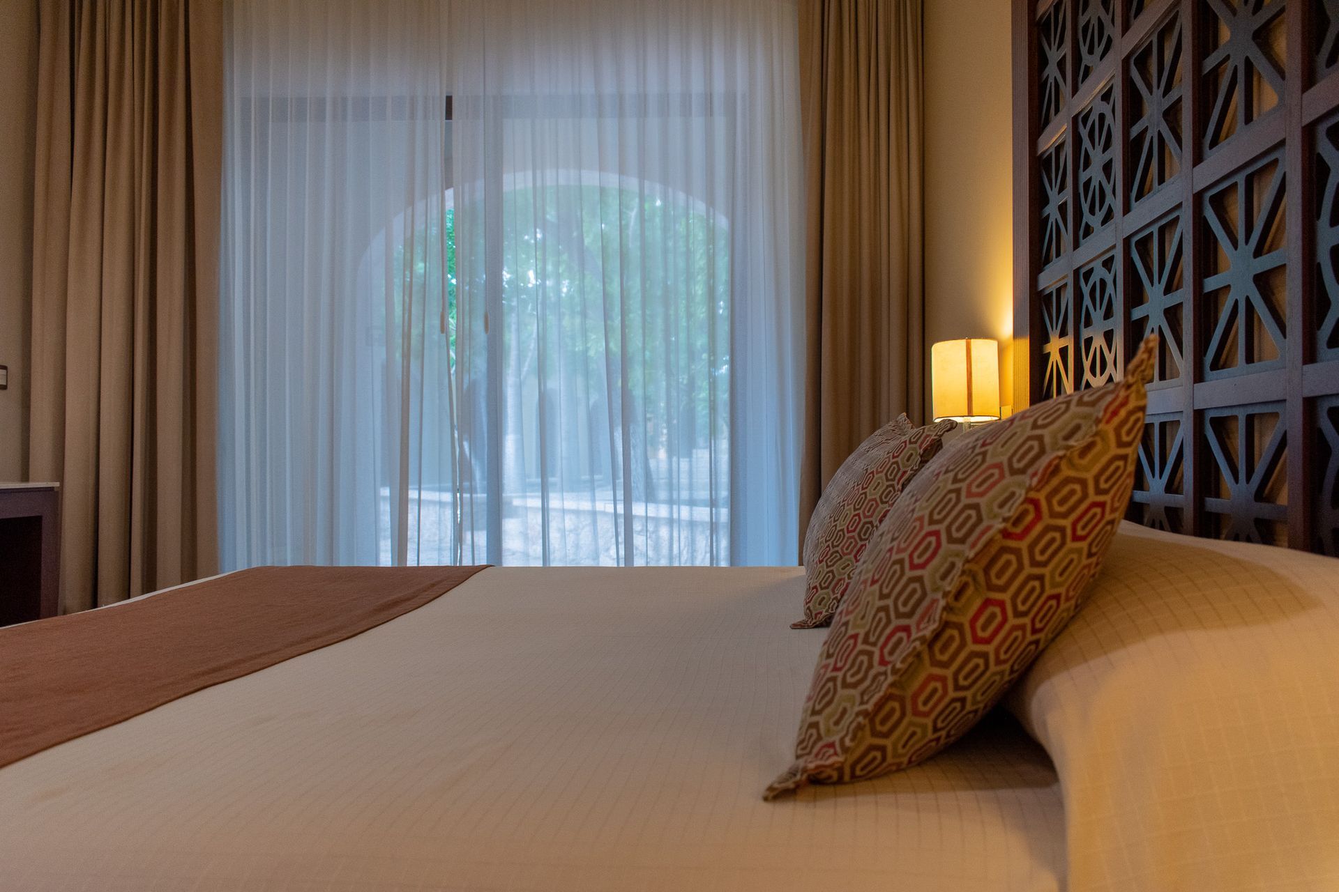 Una habitación de hotel con una cama tamaño king y una puerta corrediza de vidrio.
