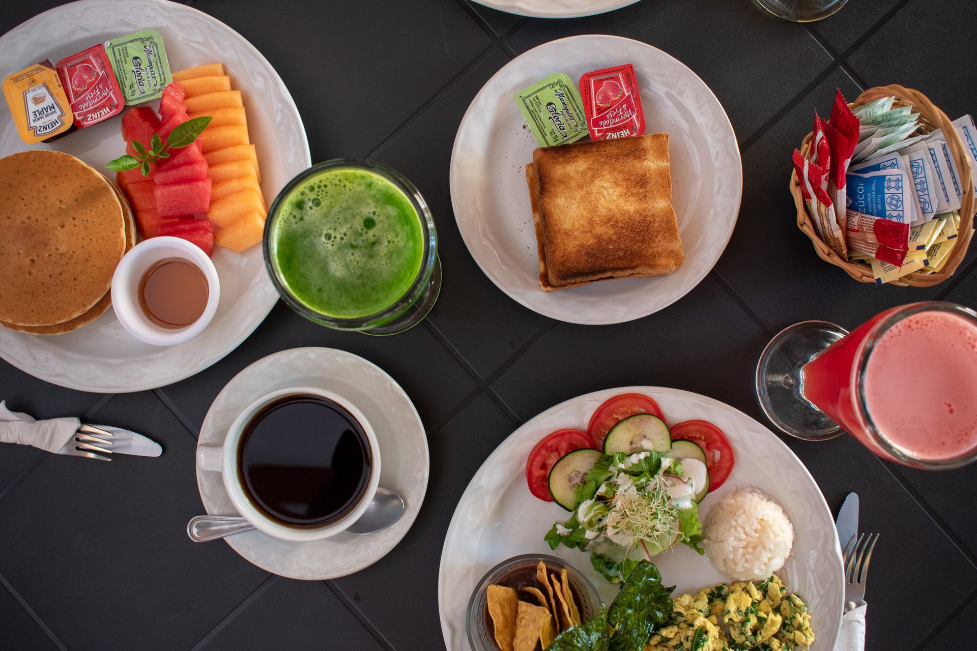 Una mesa cubierta con platos de comida y bebidas.