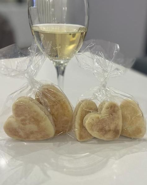 Bakestone Wales | A glass of wine and a bag of heart shaped cookies on a table.