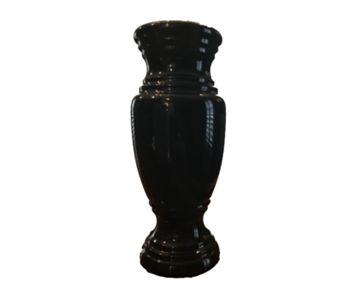 A black vase is sitting on a white surface