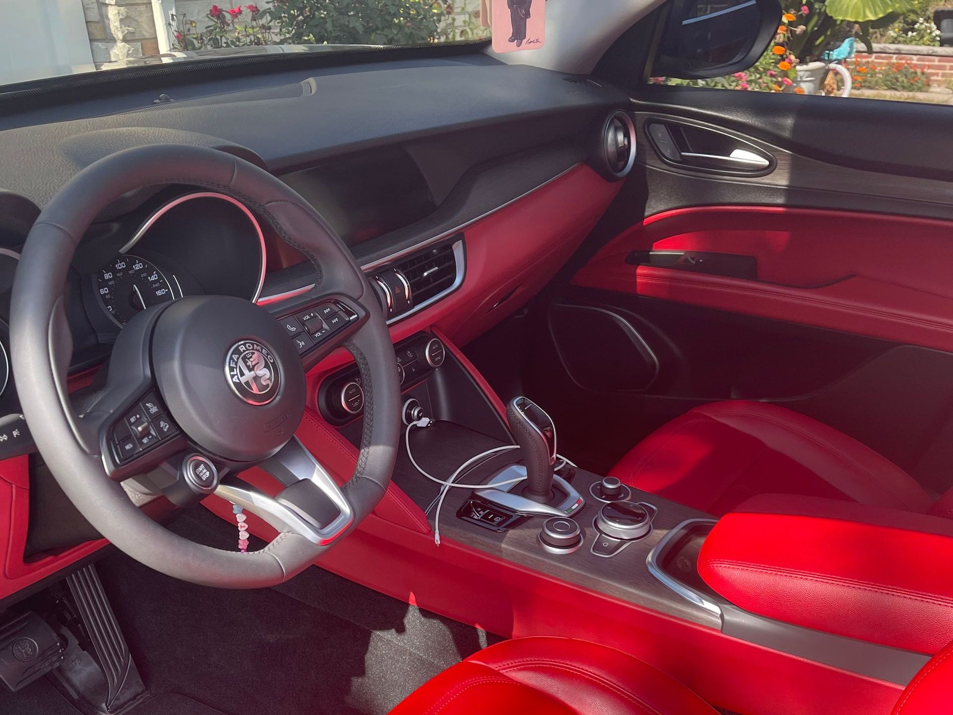 The interior of a car with red seats and a steering wheel