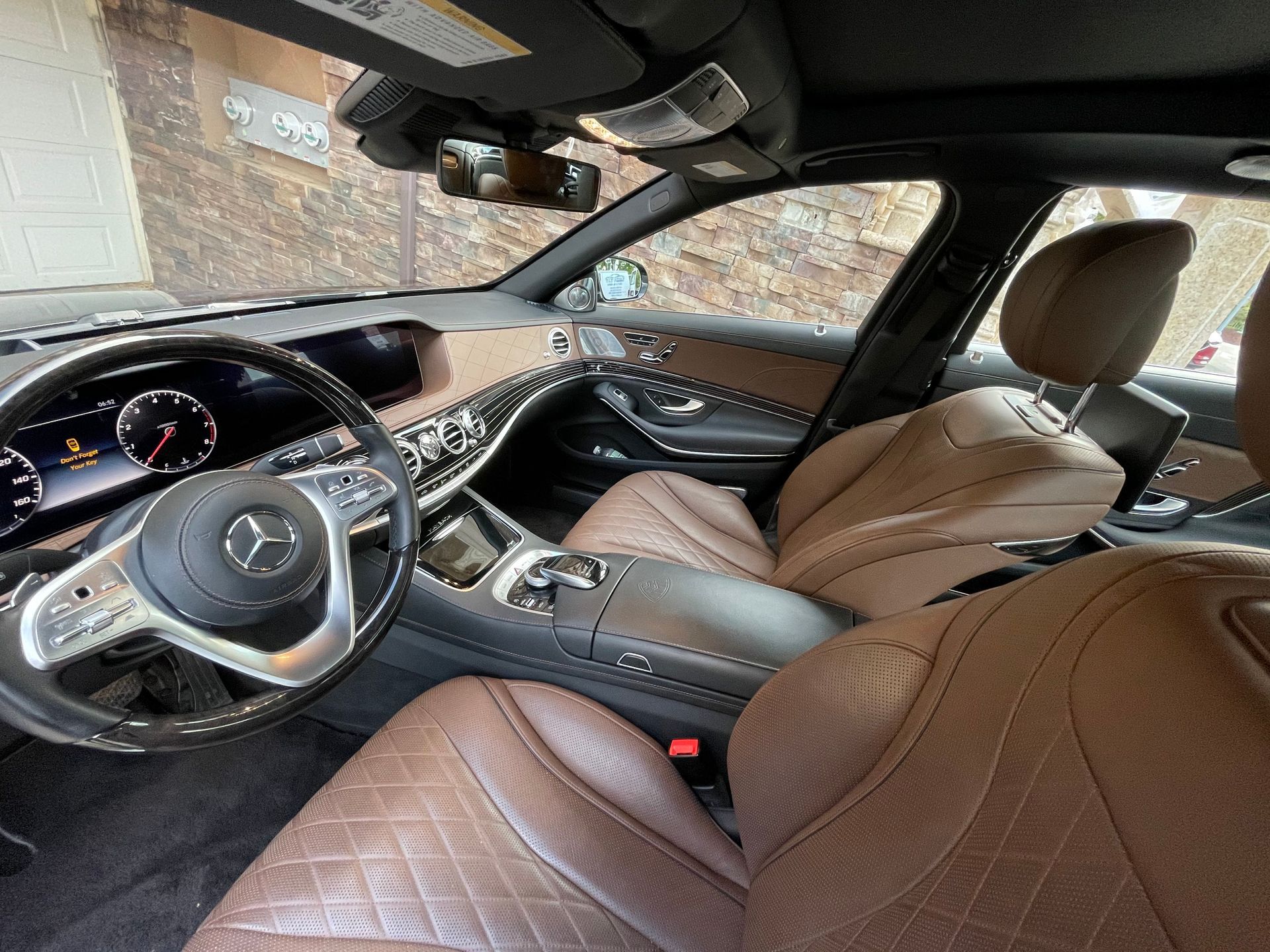 The interior of a mercedes benz s class with brown leather seats and a steering wheel.