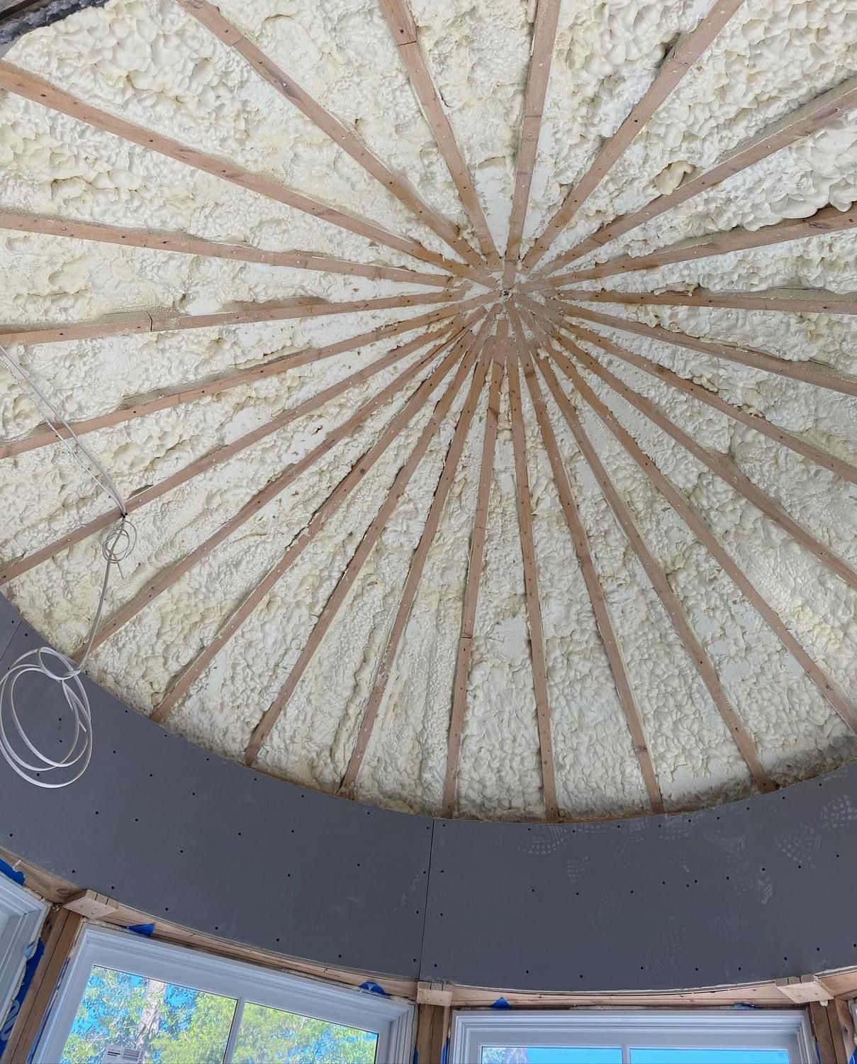 Ceiling dome with radial beams and central starburst pattern above a room