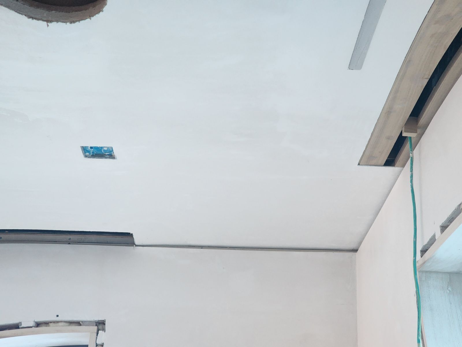 White ceiling with a small blue sticker and a window frame on the right side