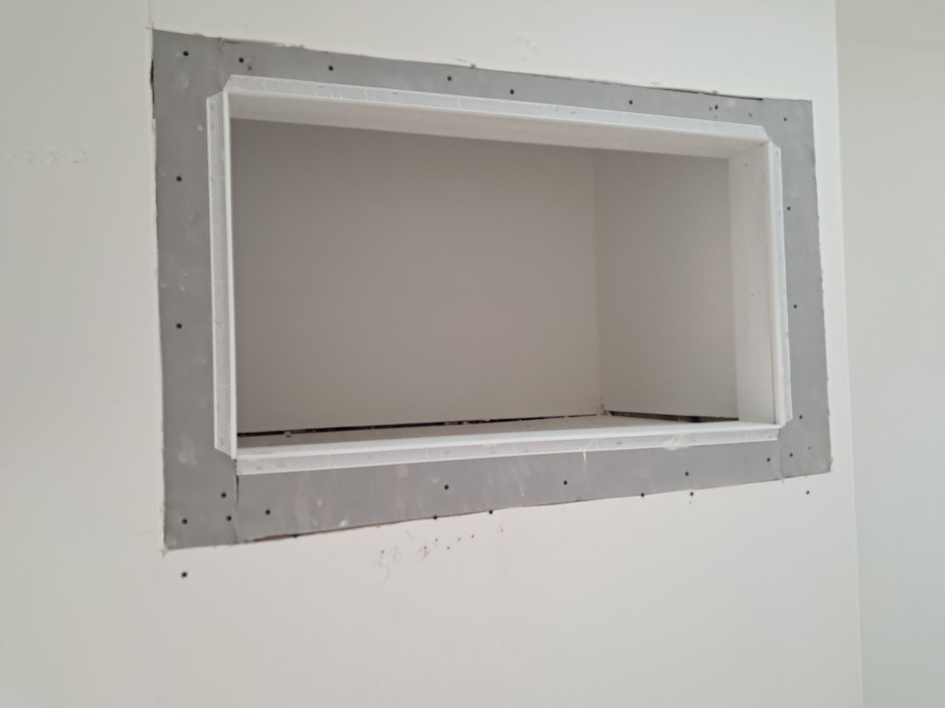 Small rectangular wall niche with gray trim in a white interior wall