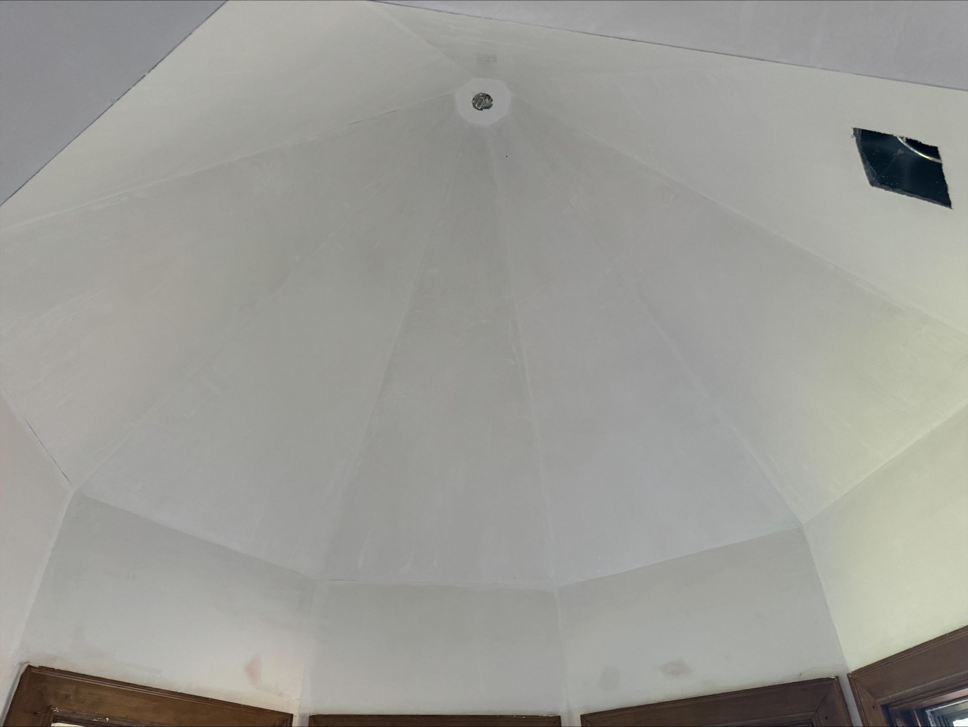 White domed ceiling with a central vent and small windows near the top.