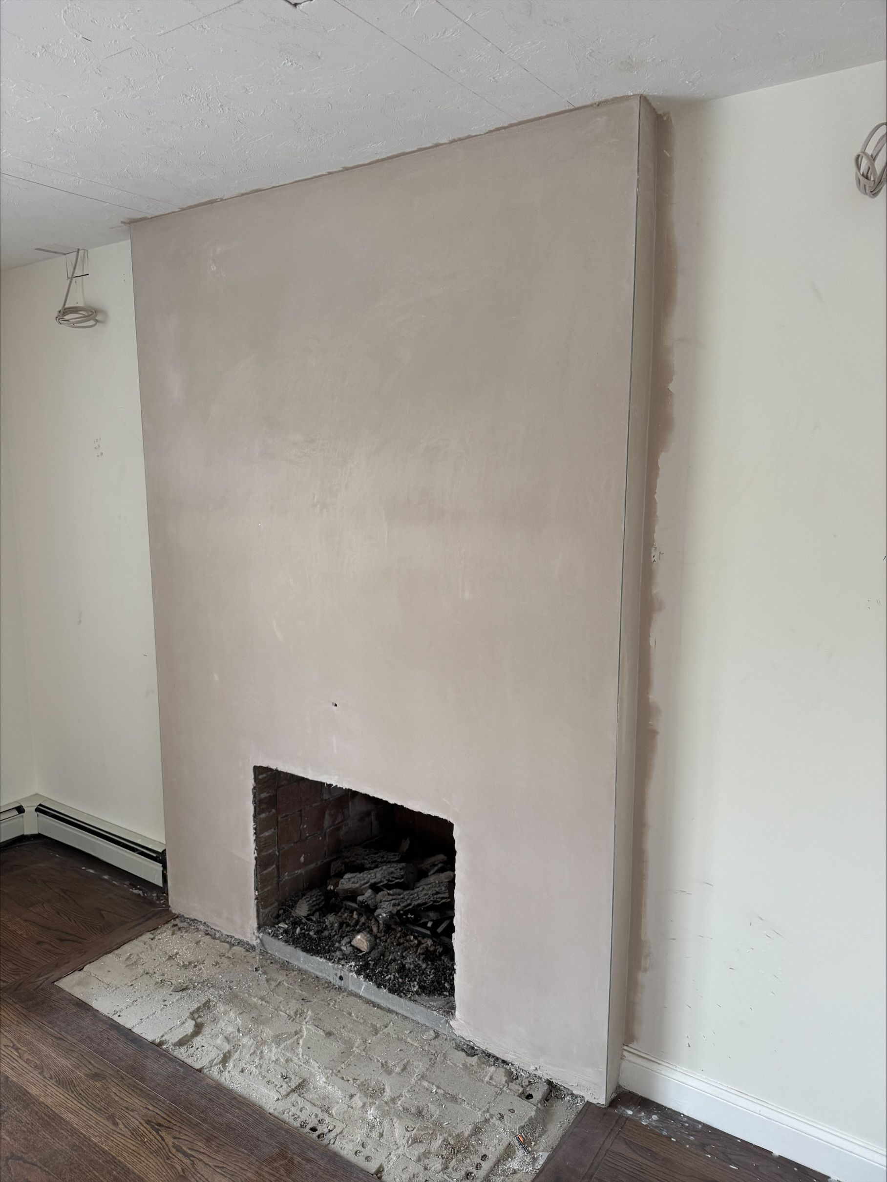 Living room with unfinished beige fireplace and dark firebox on a white wall