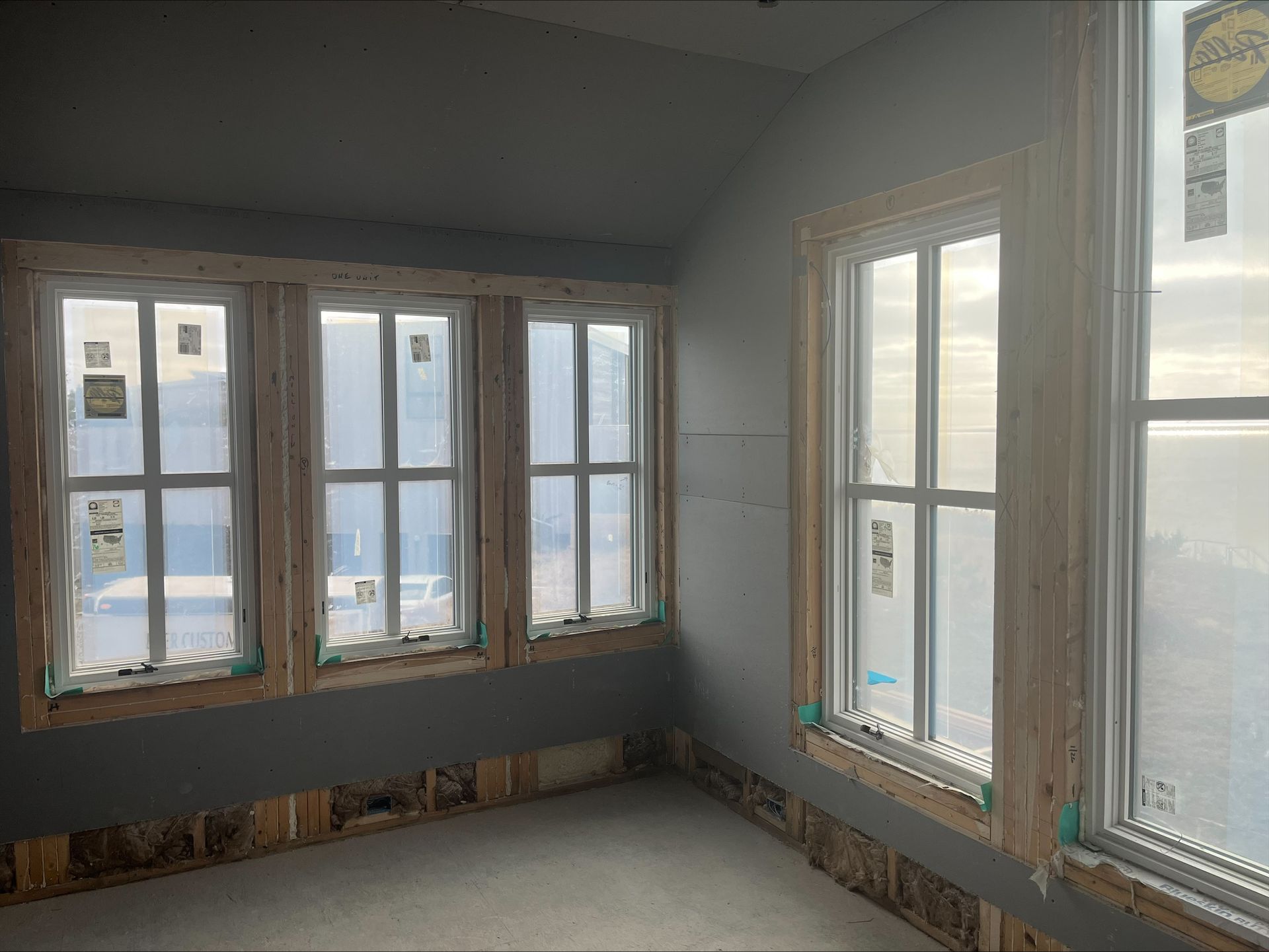 Sunlit empty room with multiple windows and a view of the water outside