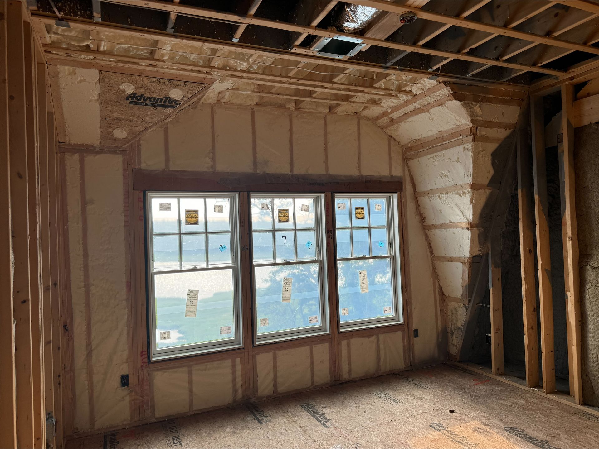 Bare room under renovation with exposed studs, unfinished walls, and a window overlooking water
