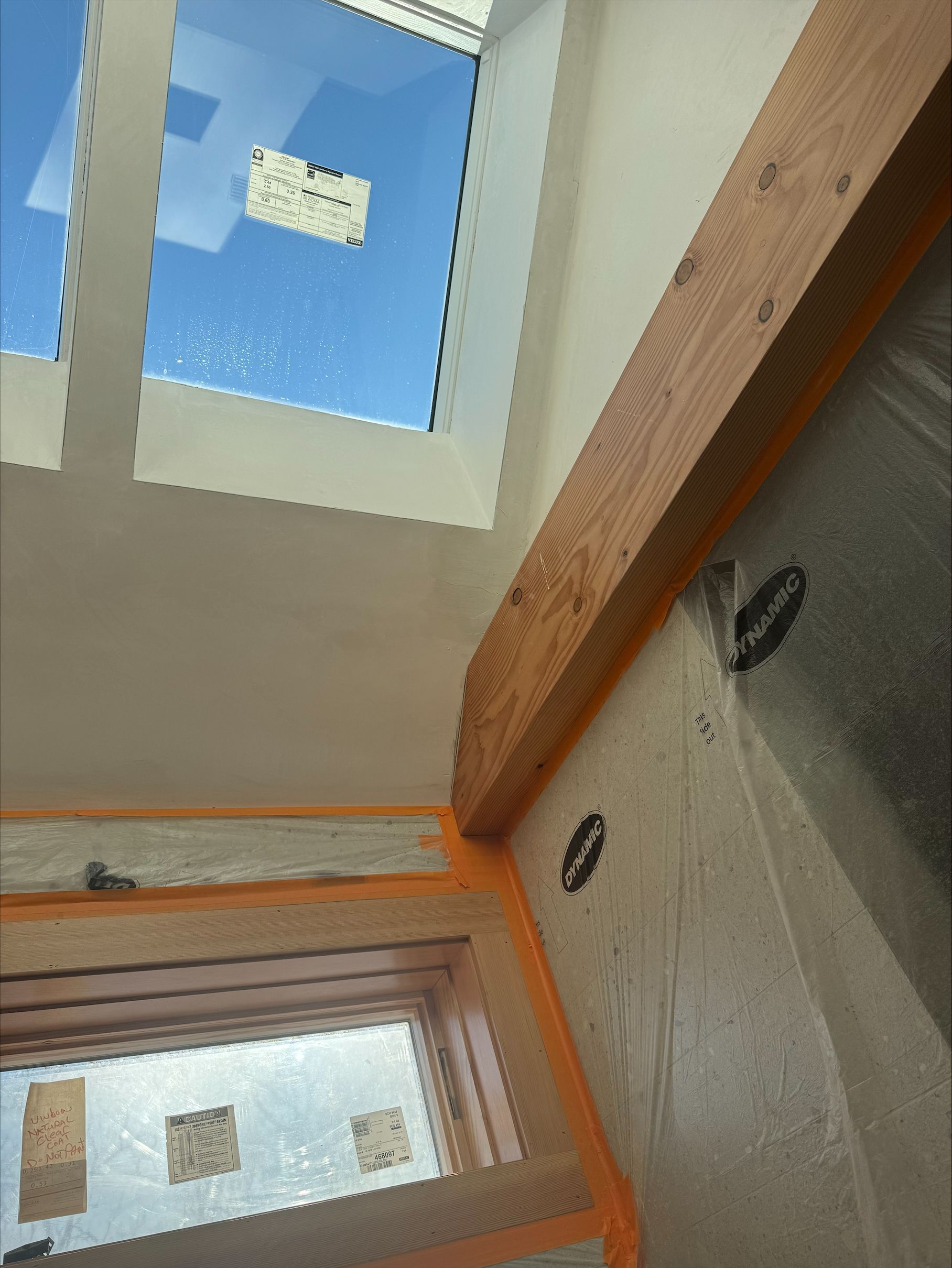 Interior hallway with white walls, wooden trim, and skylights letting in daylight.
