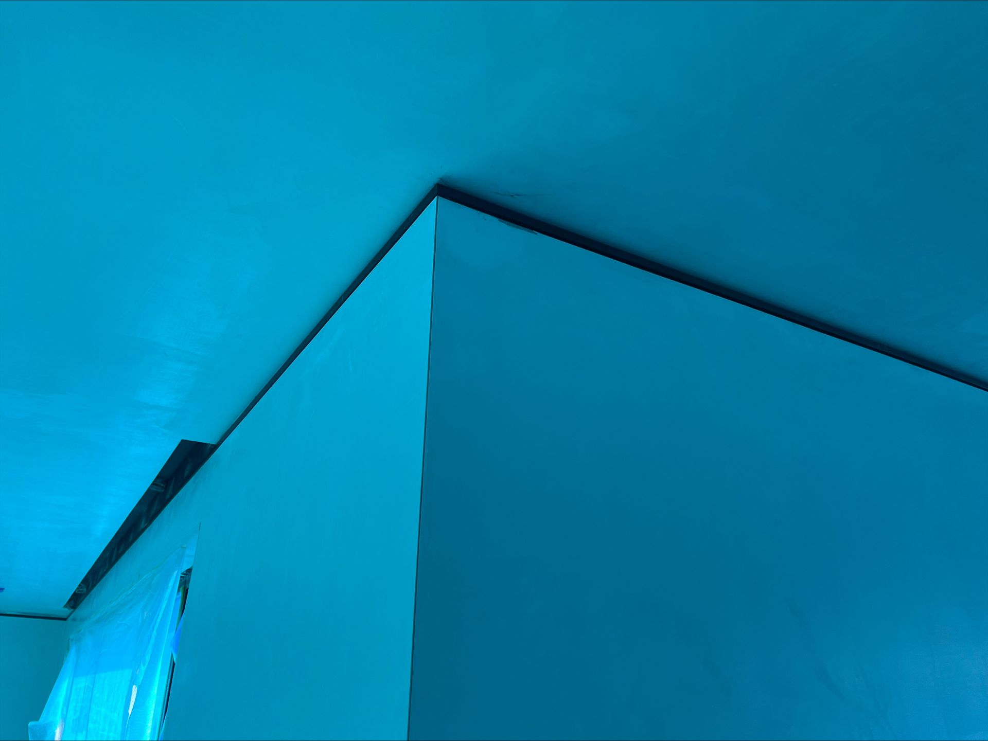 Blue building corner against a bright blue sky