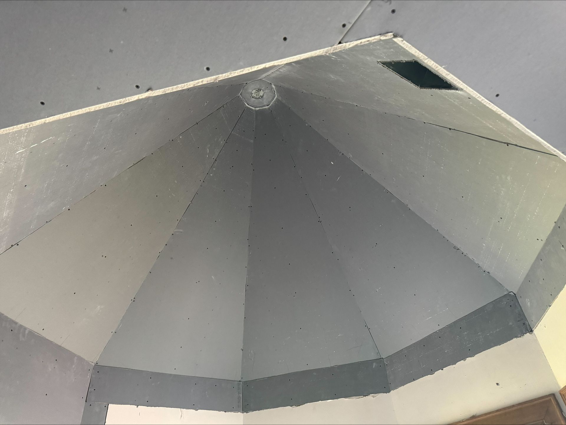 Interior view of a gray, octagonal metal structure with a dark band near the bottom