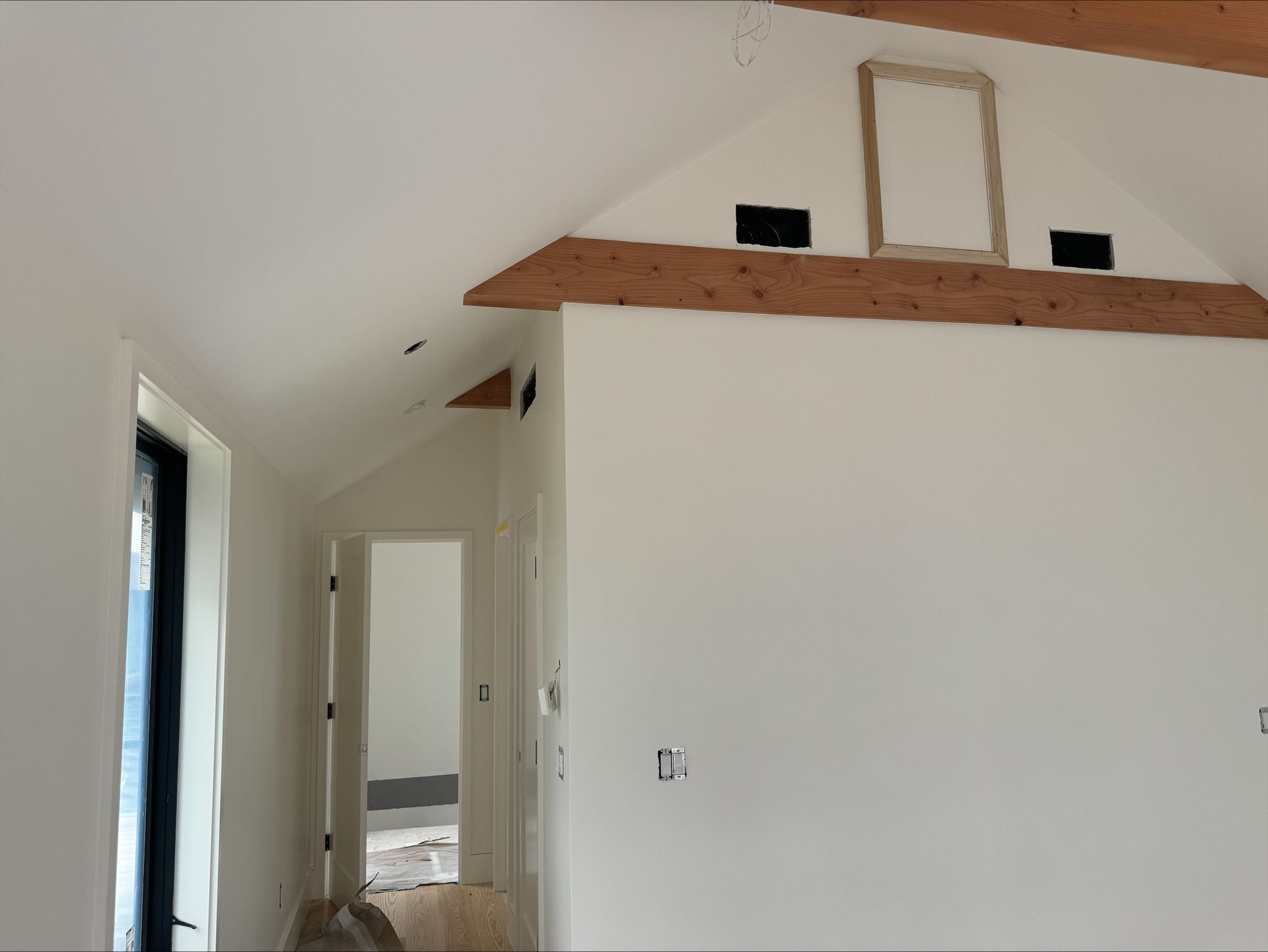 Interior hallway with white walls and unfinished ceiling trim under renovation