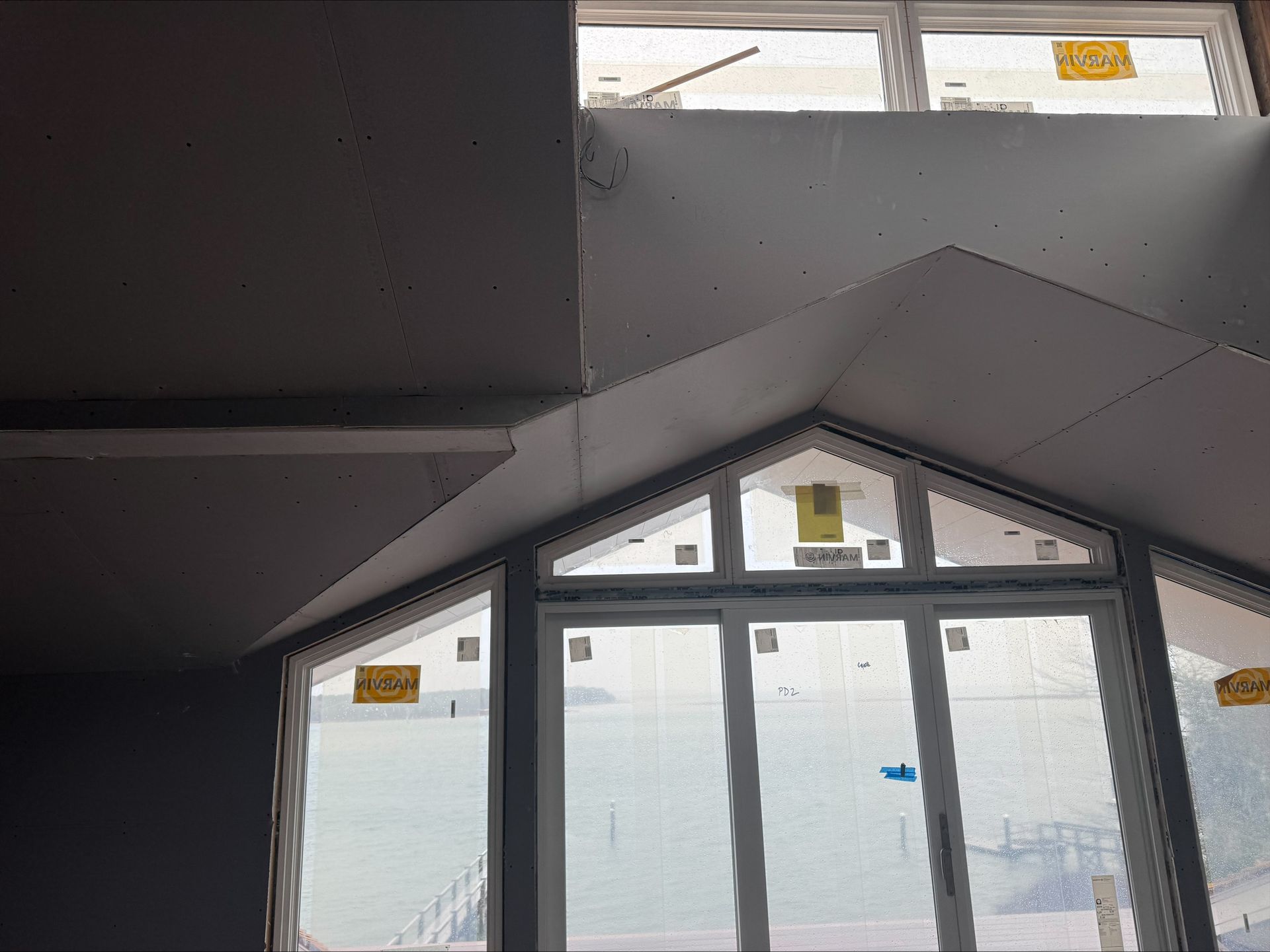 Geometric ceiling and triangular window wall with frosted glass in a modern interior