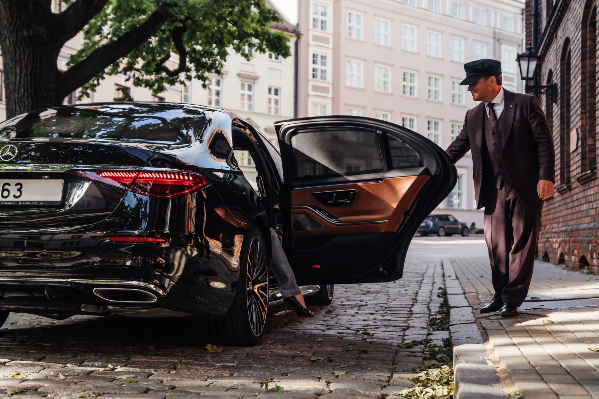 A man is opening the door of a black car. A man is opening the door of a black car.