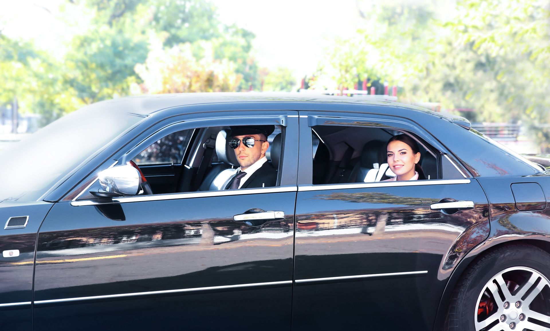 A man and a woman are sitting in a black car.