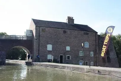 A brick building and arched bridge on a canal. A