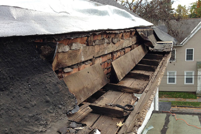 A roof with a gutter that is missing a piece of wood