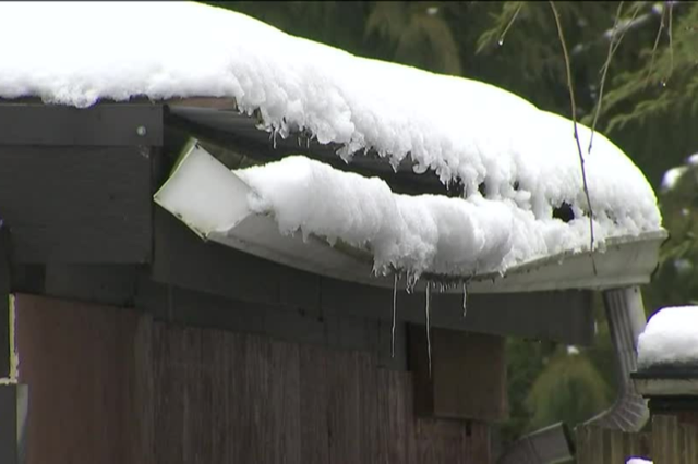 A roof gutter with a lot of snow on it