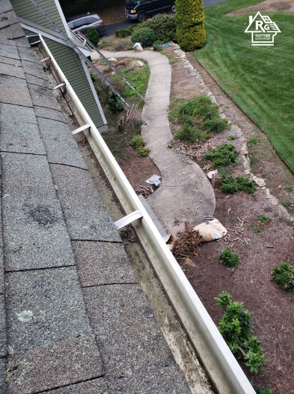 A gutter is sitting on top of a roof next to a walkway.