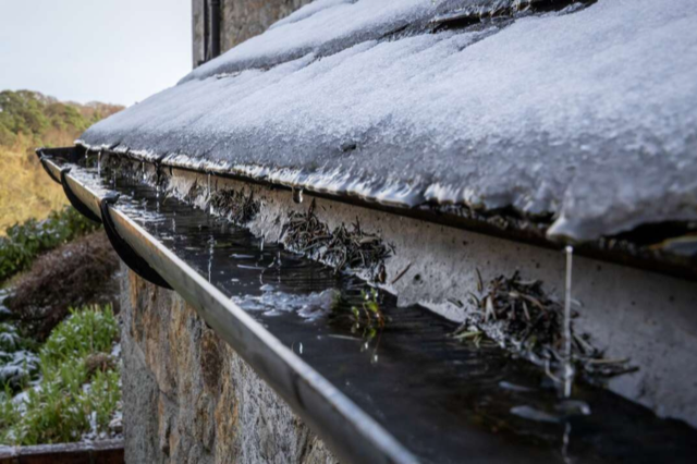 melting snow pouring on a gutter