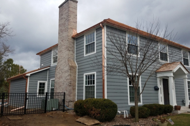 A large house with a chimney on the side of it