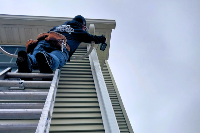 rosales gutters worker installing new a new gutter on a house