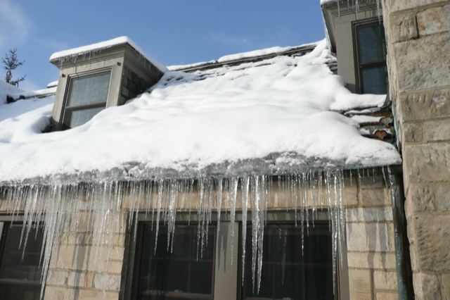 a roof with a lot of frozen snow and the gutter are frozen