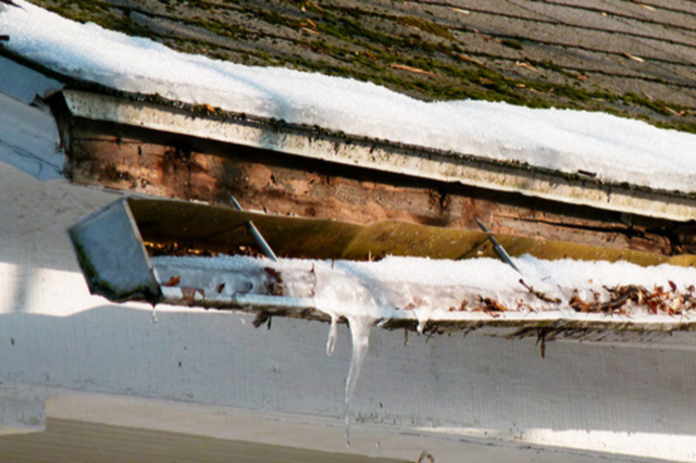 A gutter with snow on it and icicles coming out of it