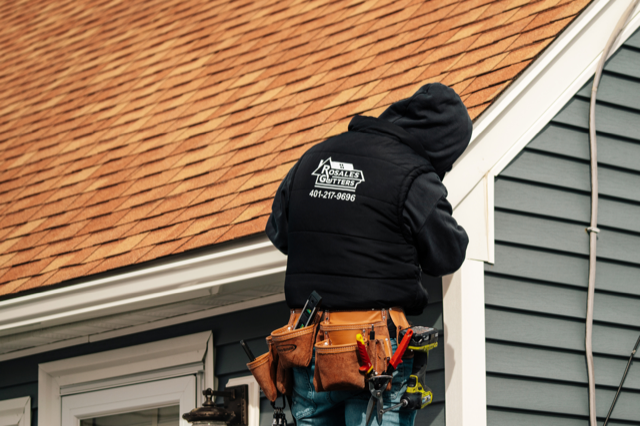rosales gutters worker working on a gutter on a house