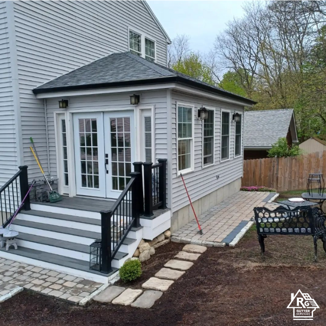 A white house with a black roof and a patio