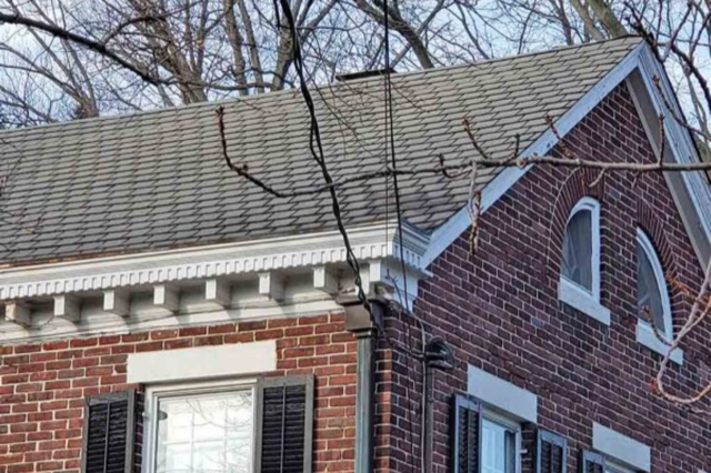 a brick house with gutters on the side