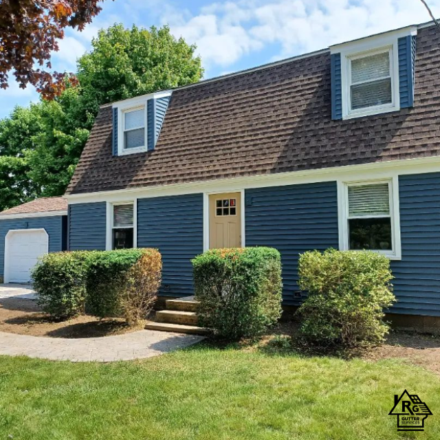 A blue house with a brown roof and white trim