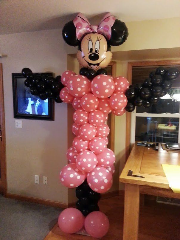 Minnie Mouse balloon figure made of pink and black balloons in a living room.