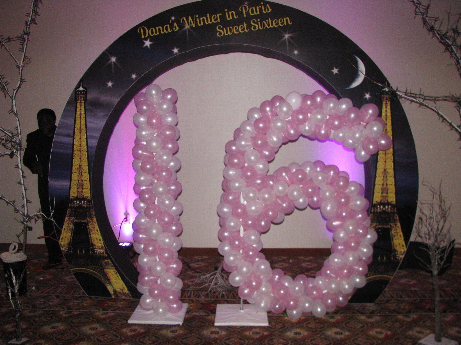 Pink balloon “16” on a decorated event backdrop with Eiffel Tower accents