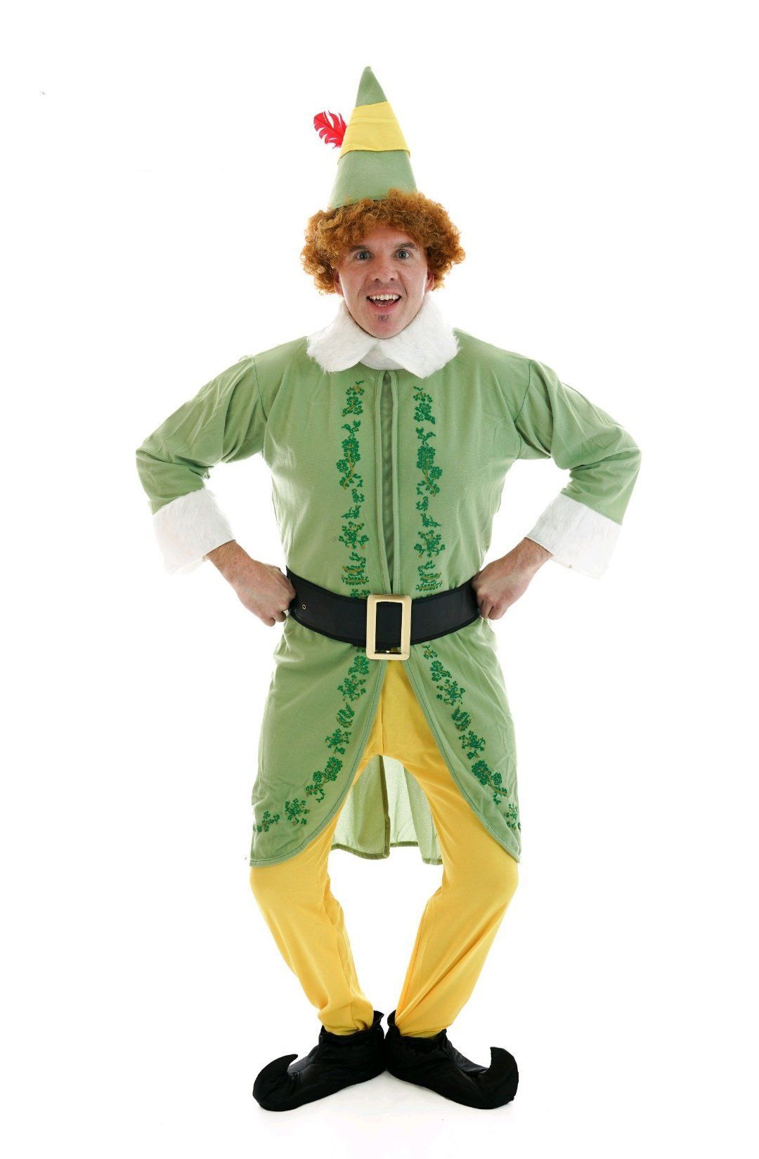 Person in a green and yellow elf costume with a pointed hat, standing with hands on hips.