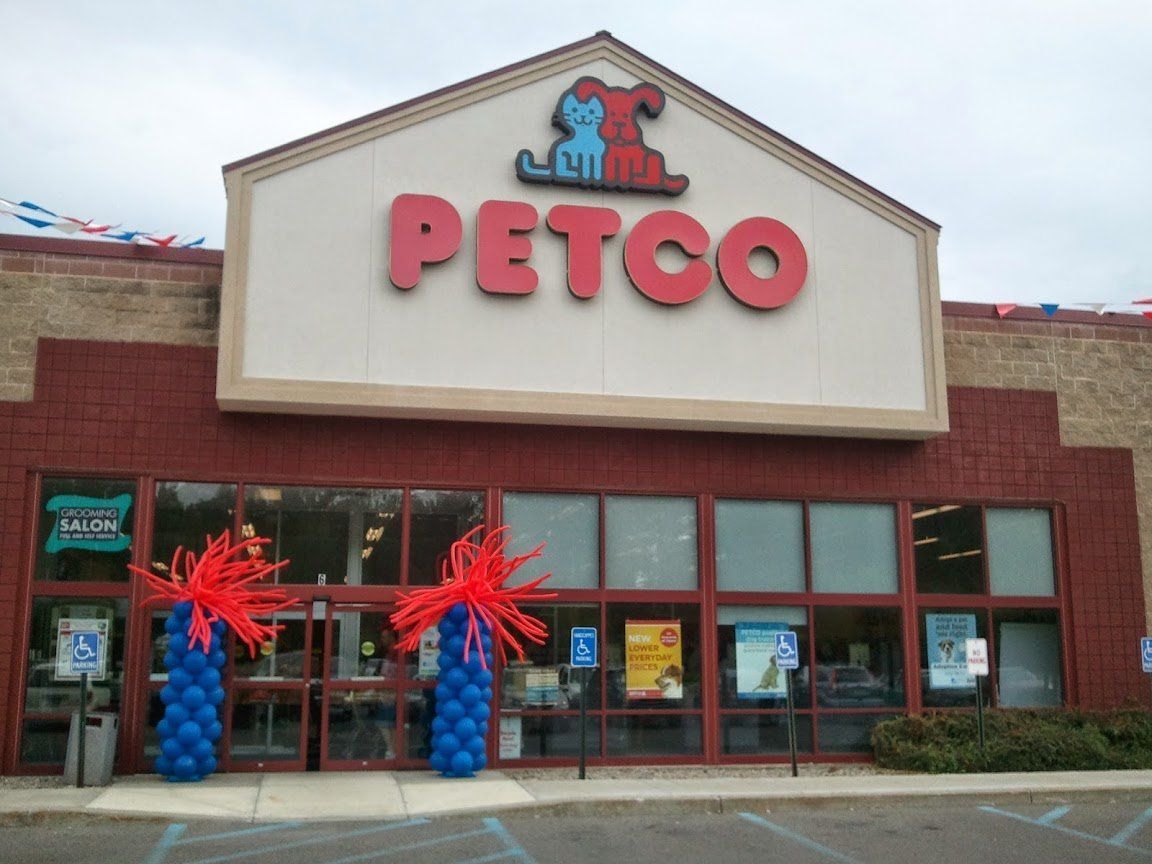 Petco storefront with red logo and festive blue-and-red balloon decorations at the entrance