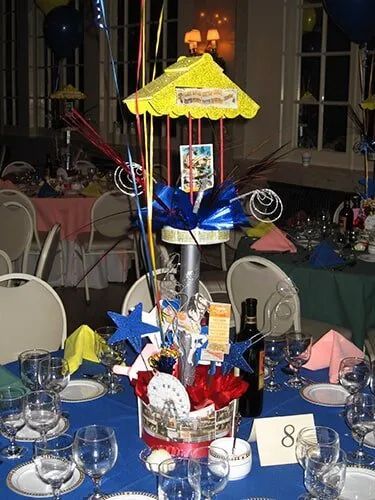 Decorative centerpiece with blue, red, and yellow ribbons on a banquet table in a dining hall