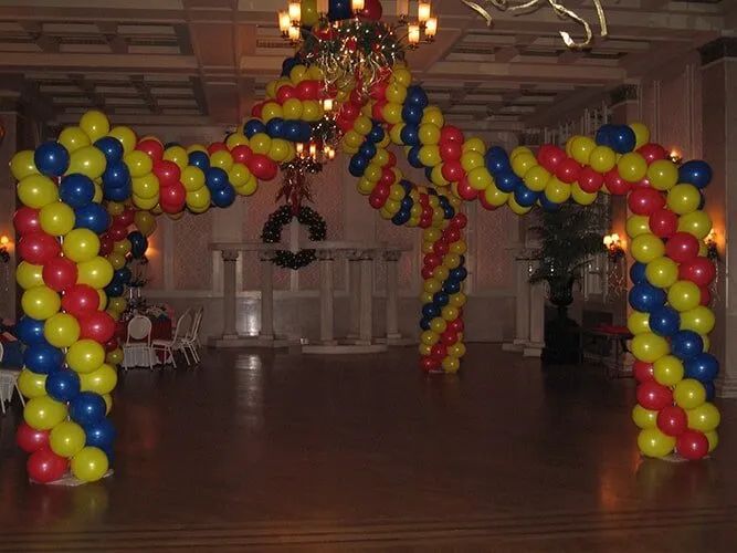 Colorful balloon archways framing a hall entrance in a decorated indoor venue