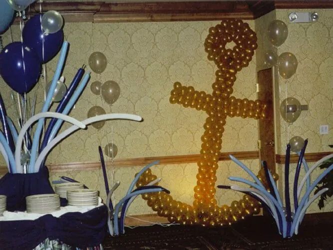 Orange balloon anchor centerpiece with blue-and-white balloon decorations in a banquet room