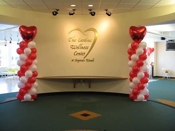 Balloon-decorated entrance to The Gallery Wedding Center with red and white heart columns