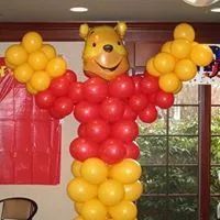 Balloon Winnie the Pooh figure with red shirt and yellow legs in a room by a window
