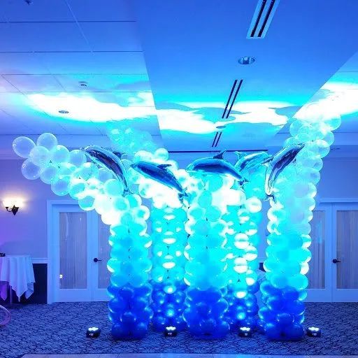 Blue balloon dolphin display in a banquet hall, with translucent balloons and bright blue lighting.