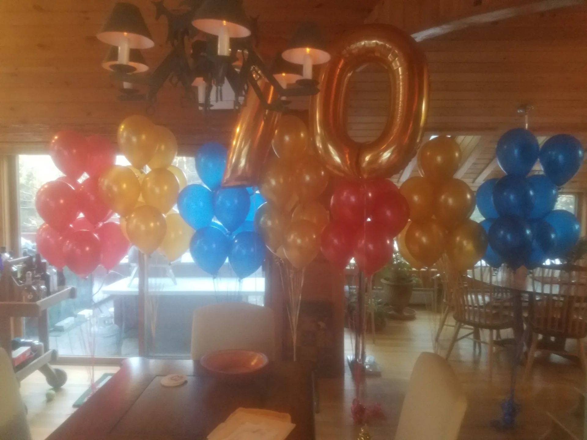Colorful balloon display with large gold “1” and “0” in a restaurant or event space