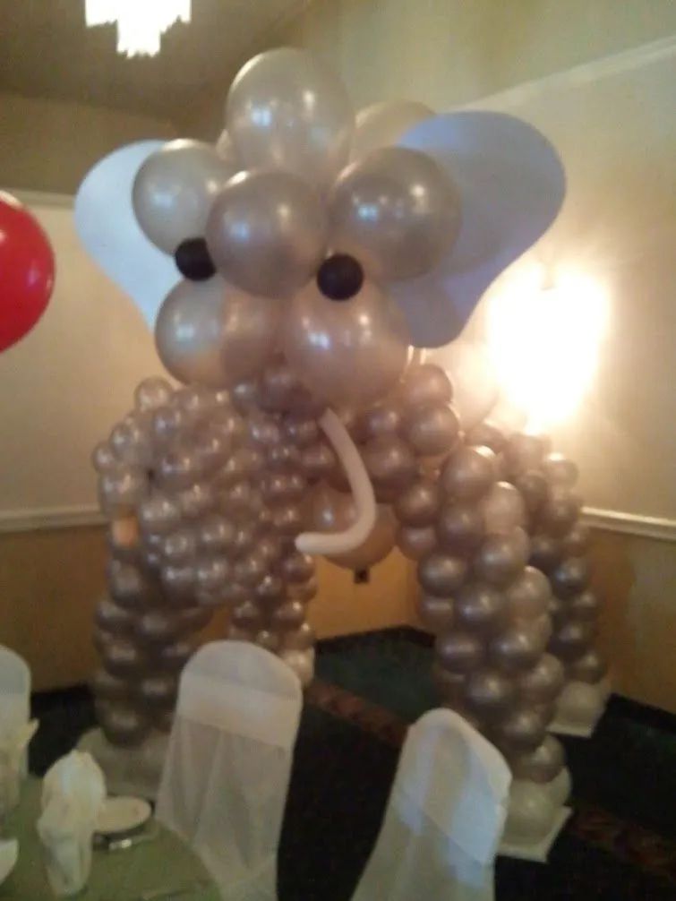 Balloon elephant sculpture with silver and beige balloons at an indoor party table